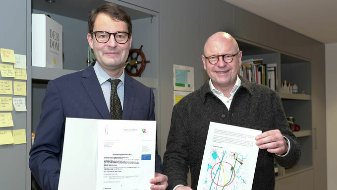 Regierungspräsident Andreas Bothe (links) und Oberbürgermeister Markus Lewe (rechts) bei der Bescheidübergabe in Münster.